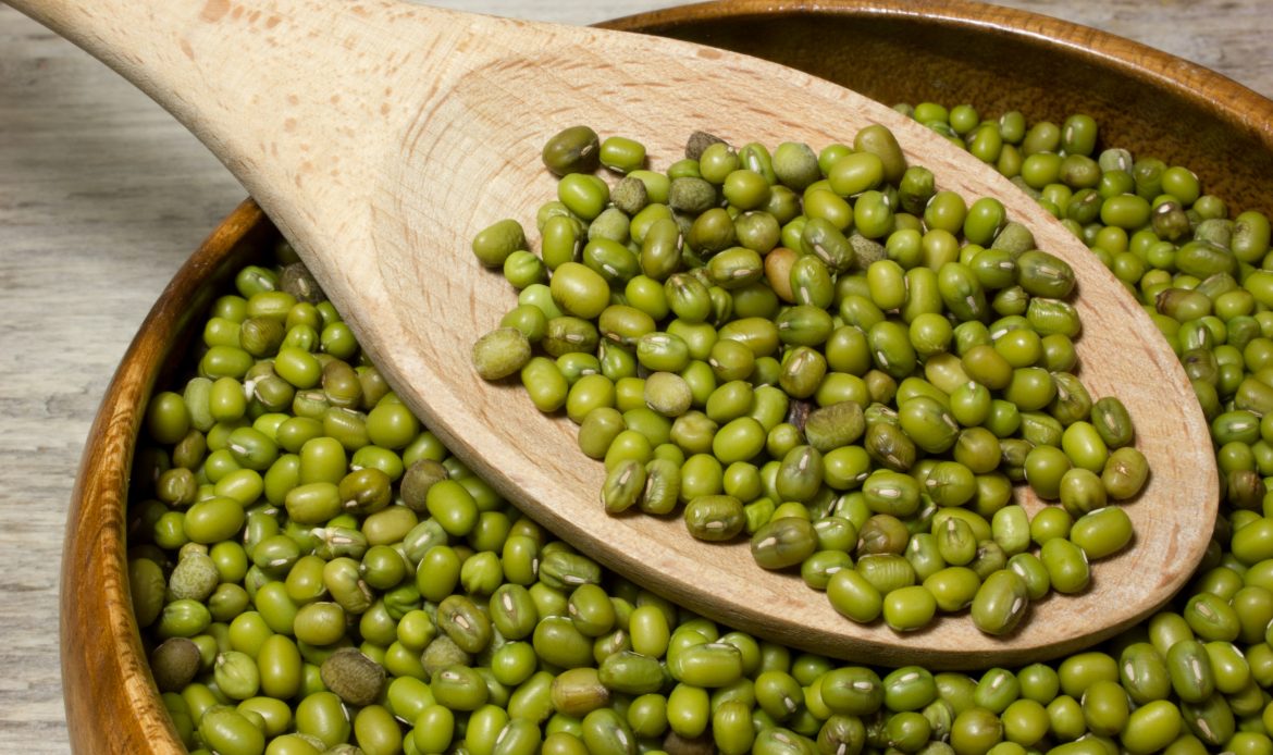 Green,Mung,Beans,And,Wooden,Spoon,On,A,Wooden,Background